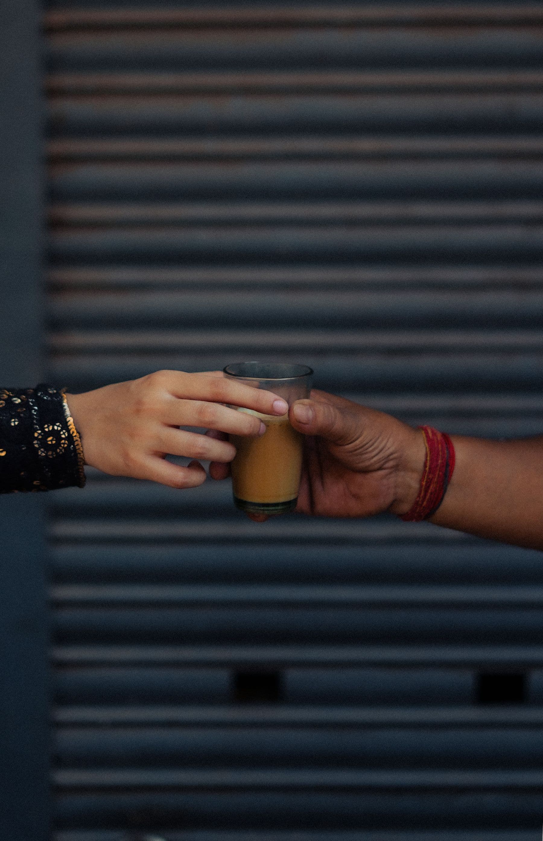A glass of tea passed between two hands